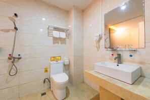 A bathroom with a shower, toilet, sink, and mirror. - Zhongshan Guanlong Hotel (Zhongshan)