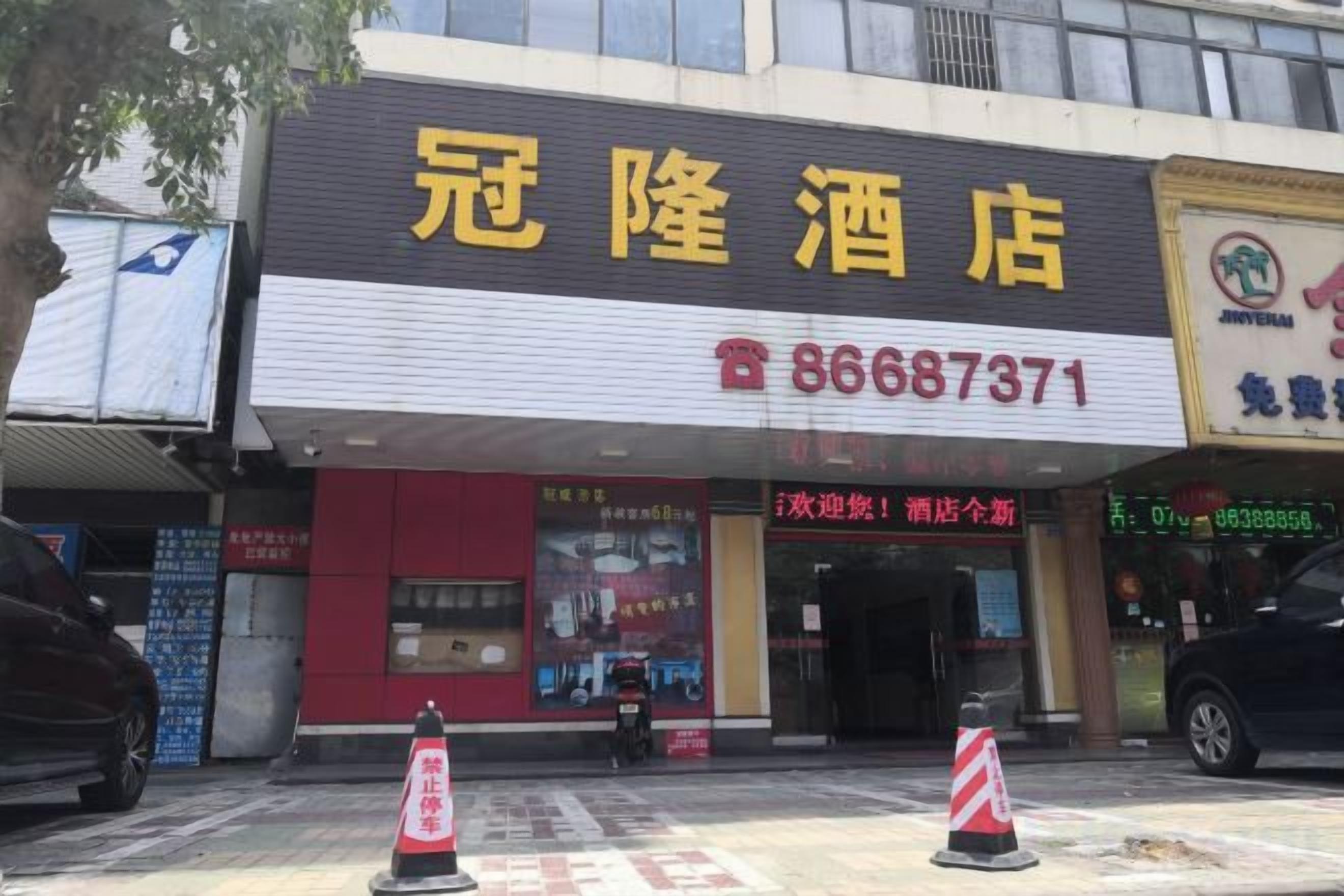 A hotel with a prominent sign and a contact number.
