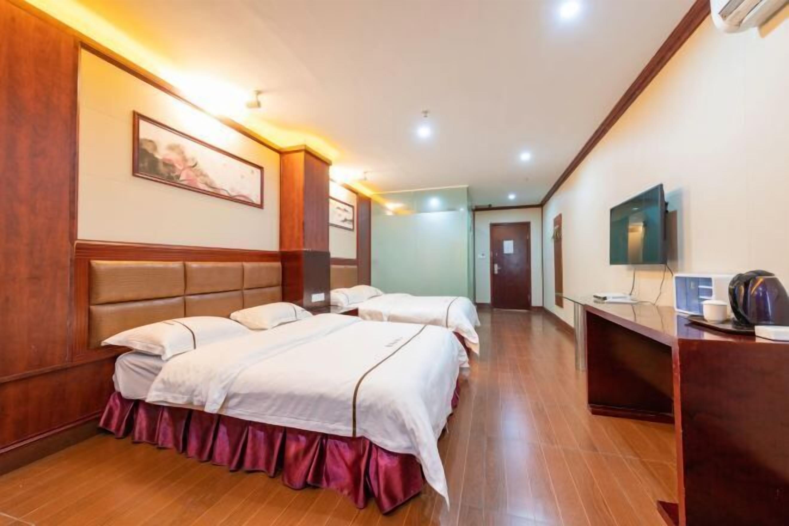 Una habitación de hotel con una cama grande, un escritorio y una televisión.