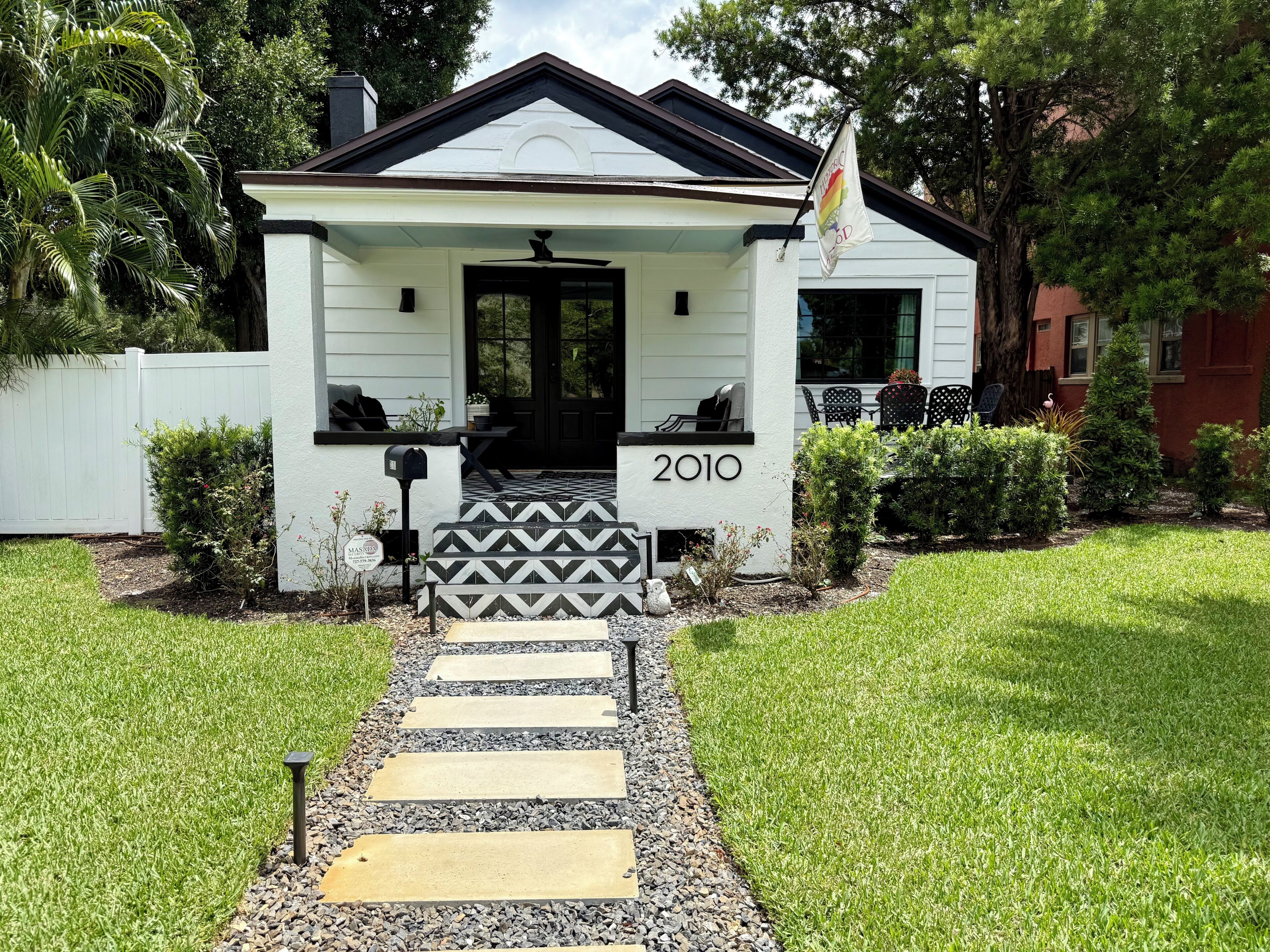 A house with a black door, a mailbox, and the year 2010 on the front.