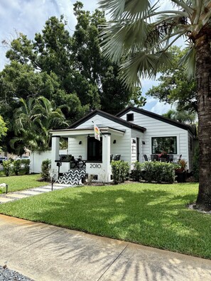 A single-story house with a front porch, a mailbox, and a small garden.