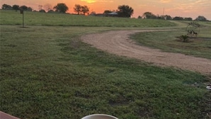 A mug on a wooden surface with a sunset view in the background. - Country Cabin  10 miles from Round Top (Burton)