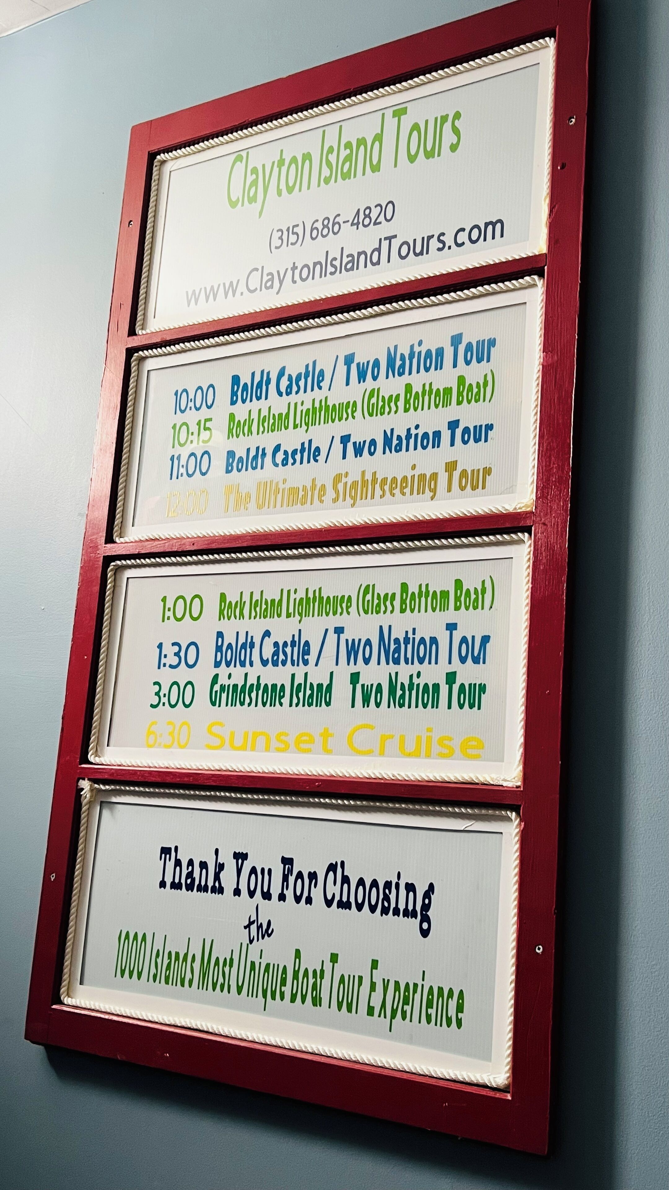 Señal con los horarios de Clayton Island Tours e información de contacto.