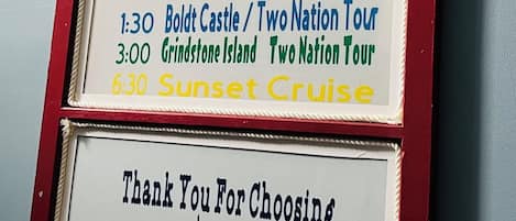 Señal con los horarios de Clayton Island Tours e información de contacto.