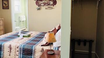 A bedroom with a bed, a nightstand, a lamp, and a wall-mounted shelf with a fish decoration.