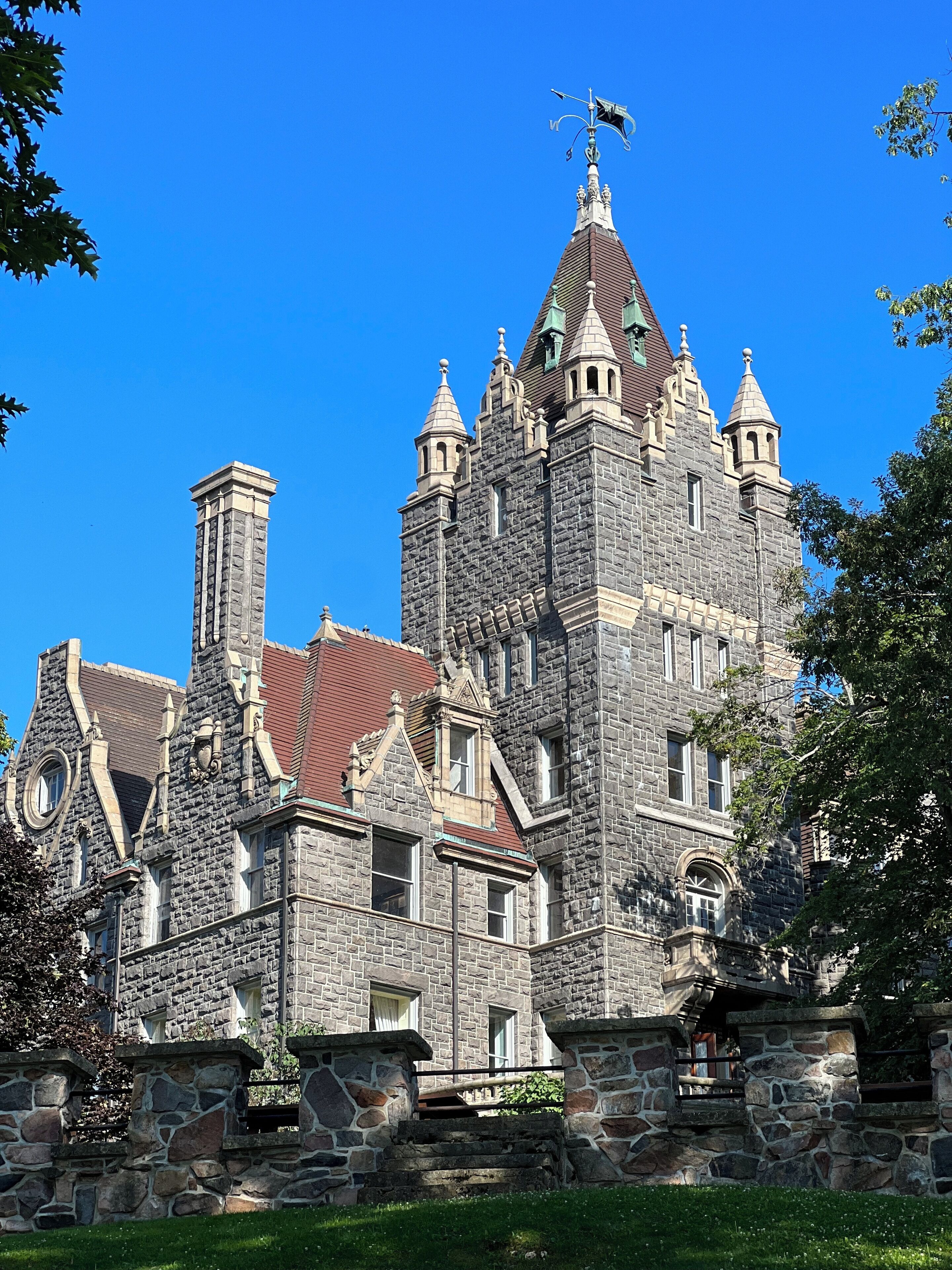 Un grand bâtiment historique en pierre, doté de nombreuses tours et d’un imposant clocher.