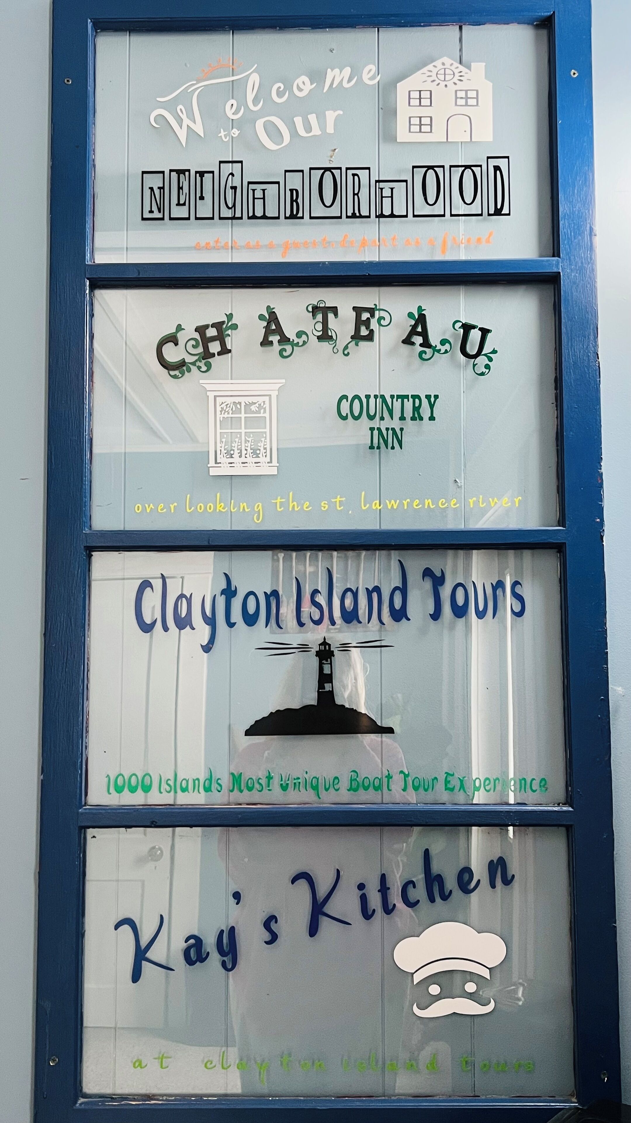 Un letrero con varios nombres de negocios, incluyendo 'Country Inn' y 'Clayton Island Tours'.
