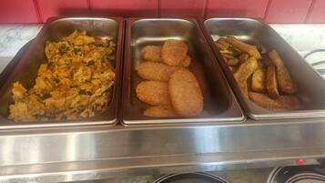 Three food trays with scrambled eggs, fried patties, and French fries.