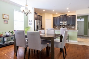 A modern kitchen with dark cabinets, a stainless steel refrigerator, and a built-in microwave.