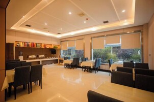 Un comedor moderno con una mesa larga y sillas, una barra con un mostrador y ventanas amplias con vistas.