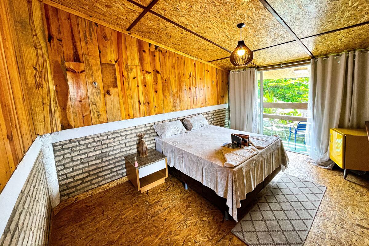 Une pièce confortable avec un lit, une petite table et une fenêtre avec des rideaux.
