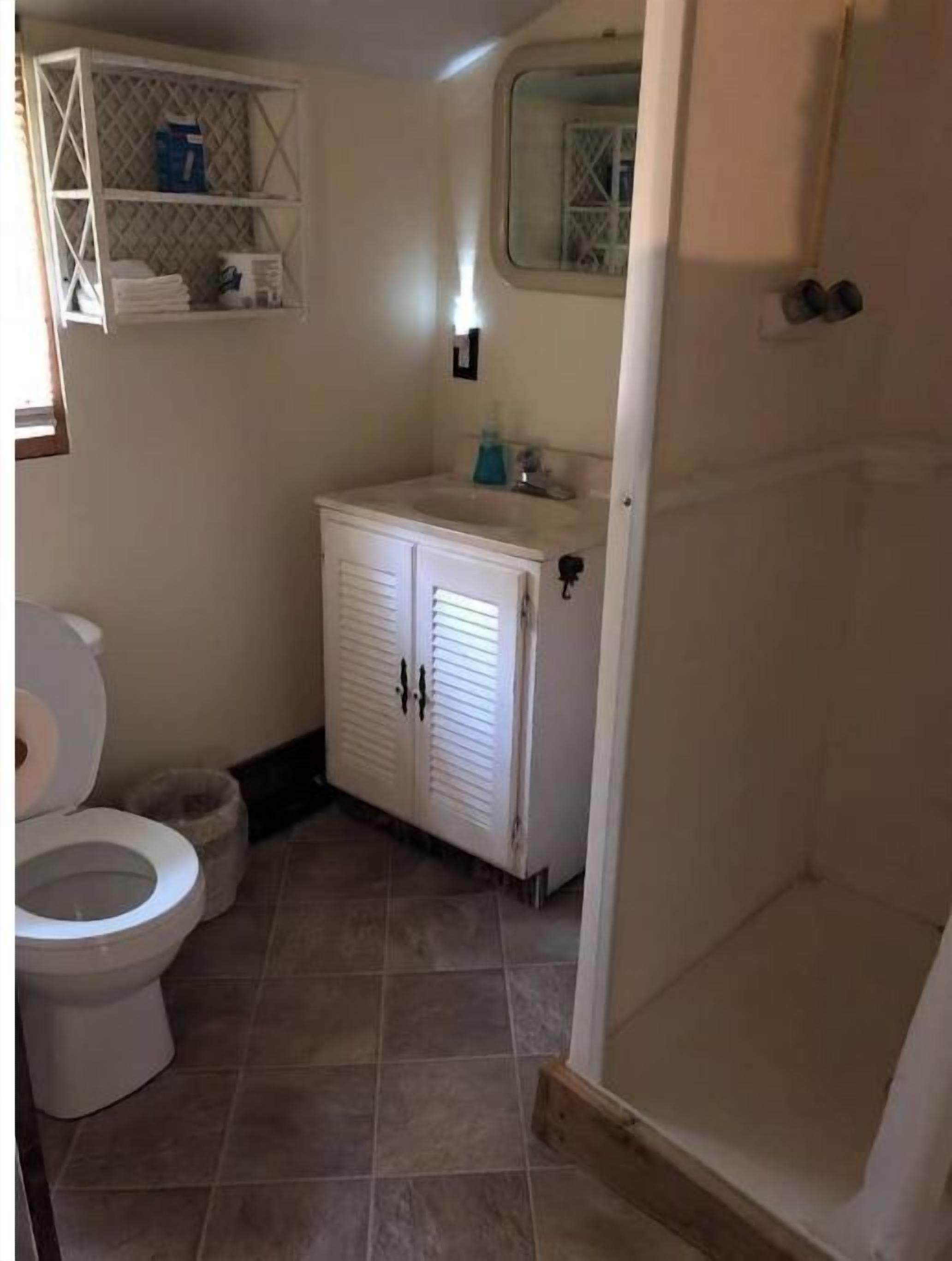 Un baño con inodoro, lavabo y armario.