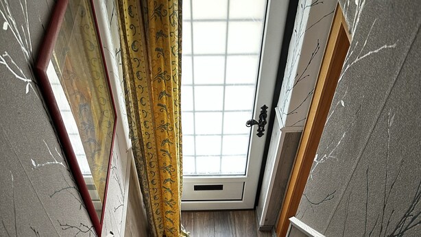 A staircase leading to a room with a window and a door. - Small, cozy semi-detached house on a large plot (Heide)