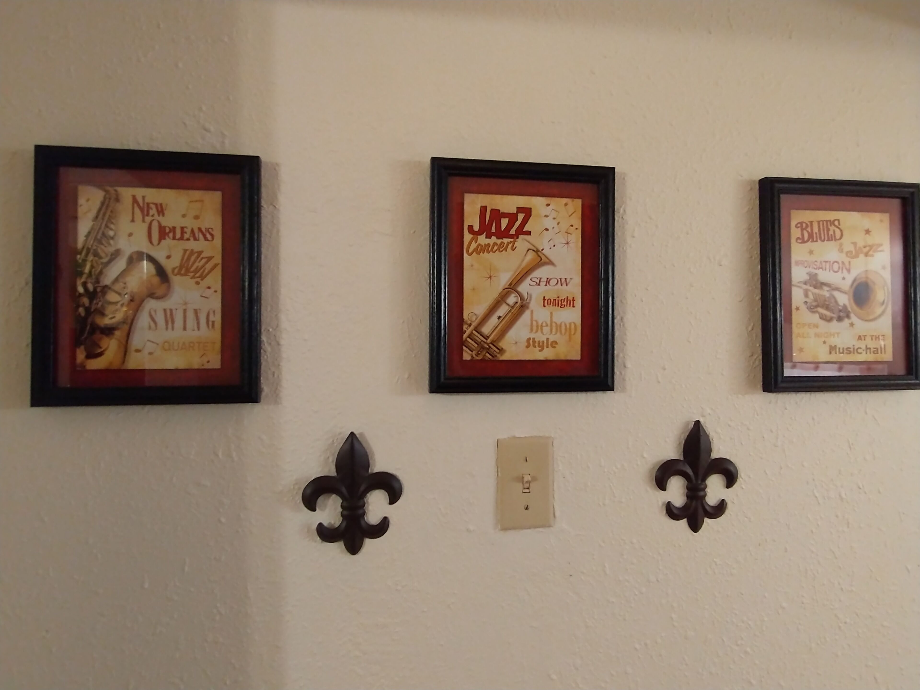 Three framed posters on a wall, each depicting different musical themes.
