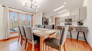 A modern kitchen with white cabinets, a microwave, and a coffee machine.