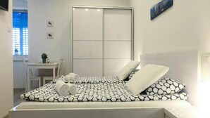 Une chambre à coucher avec un lit, un bureau et une fenêtre.
