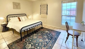 2 habitaciones, escritorio y tabla de planchar con plancha