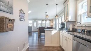 A modern kitchen with white cabinets, stainless steel appliances, and pendant lighting. - Perfect Lake House Getaway! (Waterford)