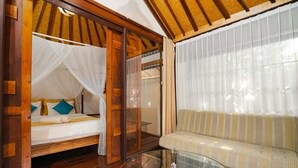 A room with a bed, a sofa, and a glass table. - Villa Pagoda (Legian)