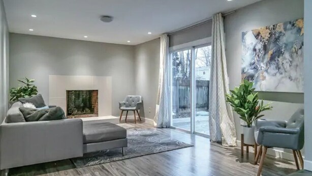 Ein modernes Wohnzimmer mit einer Couch, einem Sessel und einem Kamin.