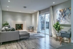 A modern living room with a sofa, armchair, and a fireplace. - MODERN INTERIOR, 4 Bed 2.5 Bath Home, Close to Shopping, Entertainment and more! (Columbus)