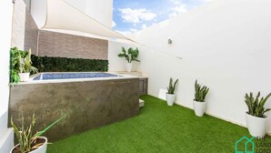 A modern outdoor space with a small pool, artificial grass, and potted plants. - New 1bd With Swimming Pool 5mn to Lac Carthage (Tunis)