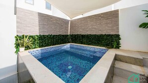 A small indoor pool with blue mosaic tiles, surrounded by a concrete deck and a green plant wall. - New 1bd With Swimming Pool 5mn to Lac Carthage (Tunis)