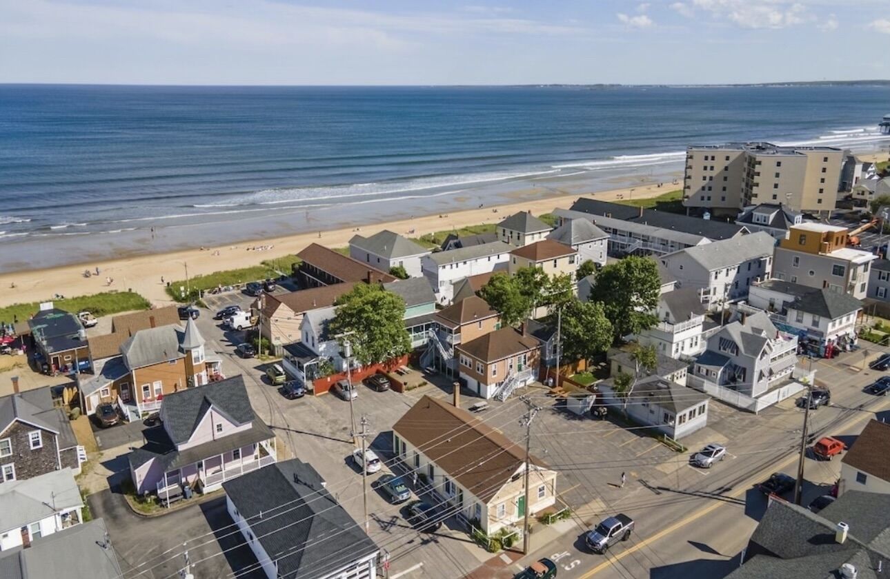 Un pueblo costero con edificios residenciales, una playa y vista al océano.