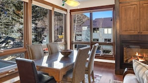 A dining area with a wooden table, chairs, and a fireplace. - Walk To Festivals! Windows, Fireplace, Hot Tub 1 Bedroom Condo by RedAwning (Telluride)