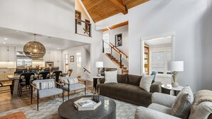 A spacious living area with a high ceiling, a dining area, and a staircase leading to another level. - Lux Home W/ Gas Fireplace, Hot Tub, 8 Min To Lift 7 Bunk Room For Kids! 4 Bedroom Home by RedAwning (Telluride)