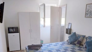 A bedroom with a bed, a wardrobe, a small desk, and a chair. - Bovolini's Room (Dubrovnik)