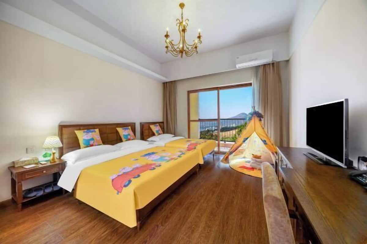 A hotel room with a large bed, a TV, a wooden desk, and a window with a view.