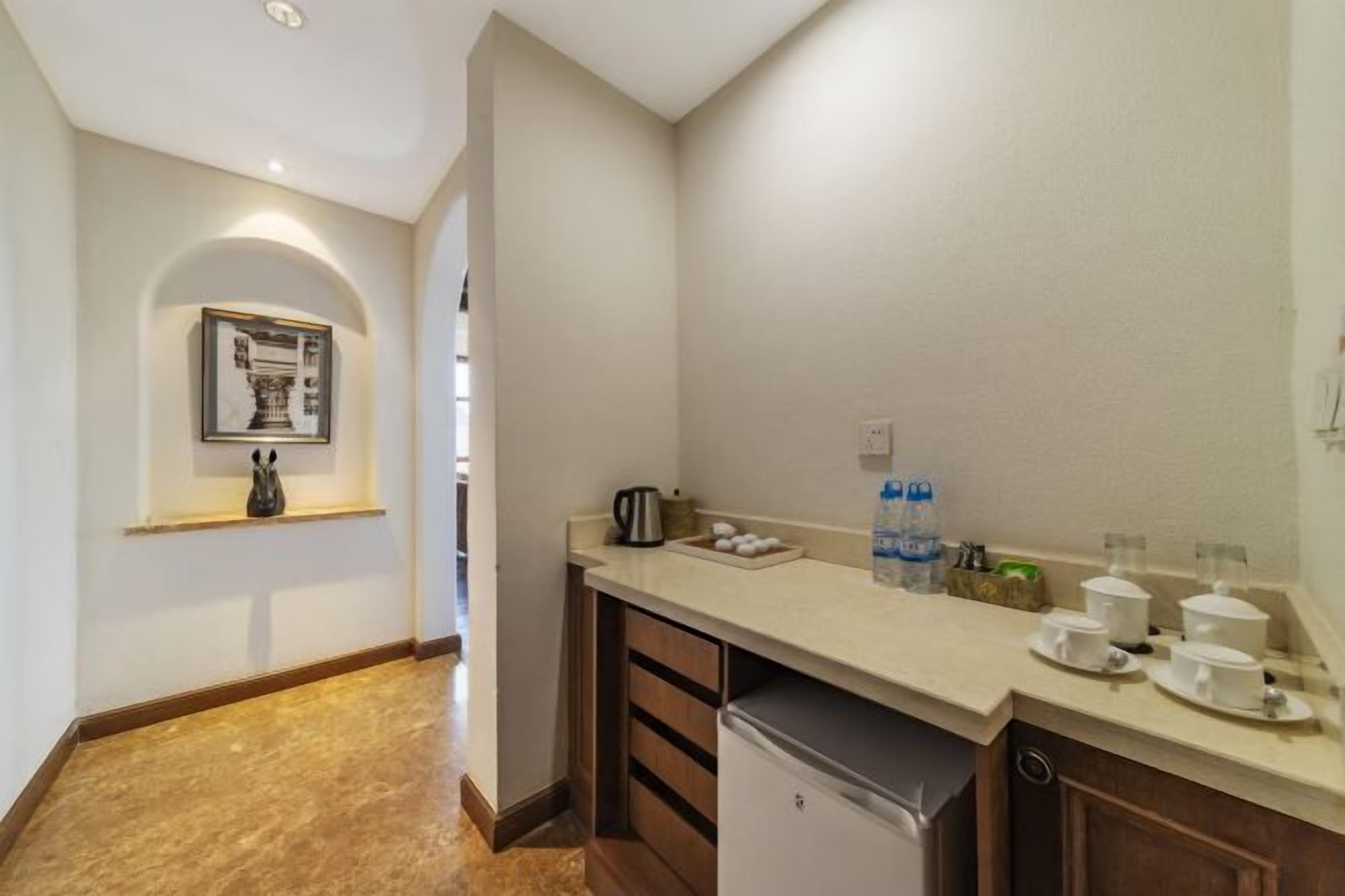 A compact kitchen with a countertop, a coffee maker, and a water dispenser.