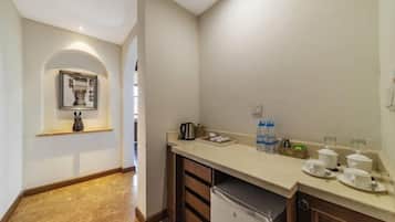 A compact kitchen with a countertop, a coffee maker, and a water dispenser.