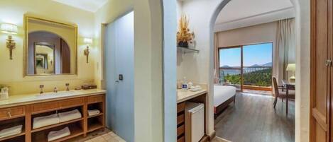 A hotel bathroom with a large mirror, a vanity with a sink, and a shower area.
