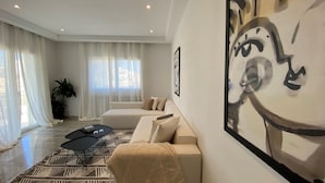 A modern living room with a sofa, coffee table, and artwork on the wall.