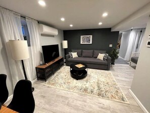 Relax in this stylish living room with a large sofa, flat-screen TV, and cozy coffee table.
