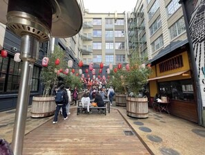 Stroll through this vibrant urban courtyard, surrounded by lush potted plants and modern architecture.