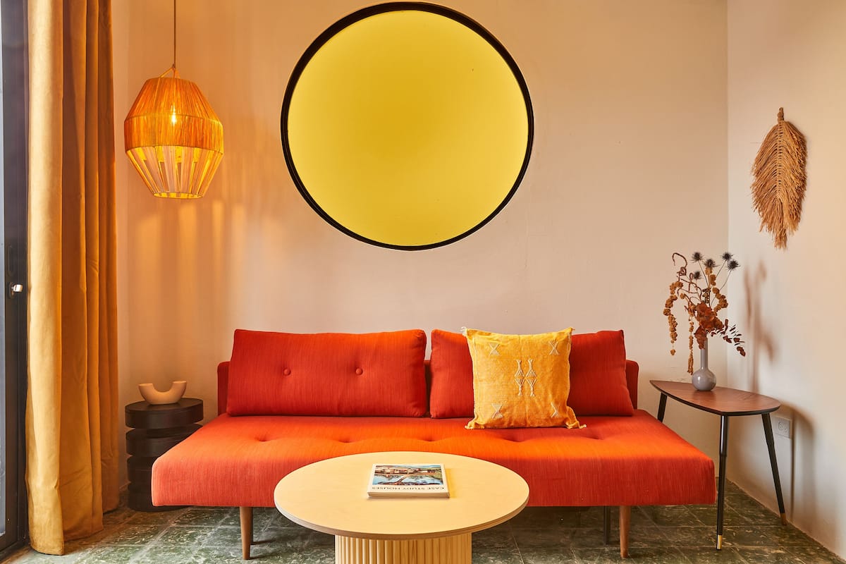 A modern living room with a sofa, a round coffee table, and a large circular wall decoration.