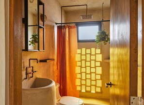 A bathroom with a large sink, a mirror, a window, and a shower area. - APT by DW (San Juan)