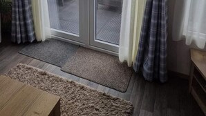 Quarto com porta de vidro deslizante que dá para uma varanda externa.