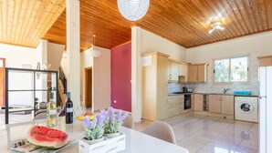 Una cocina moderna con armarios de madera, horno empotrado y lavadora.