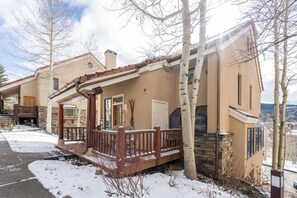 A two-story house with a covered porch and a stone fireplace. - Mountain Village Panoramic Views, Hot Tub, Fireplace 3 Bedroom Townhouse by RedAwning (Telluride)