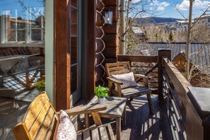 A wooden deck with outdoor seating, a view of a mountainous landscape, and a log cabin structure. - New! Chic European Style Cabin, Short Walk To Ski 3 Bedroom Home by RedAwning (Telluride)