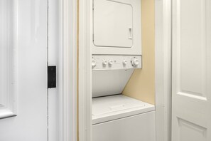 A laundry room with a washer and dryer, a control panel, and a door. - New! Chic European Style Cabin, Short Walk To Ski 3 Bedroom Home by RedAwning (Telluride)