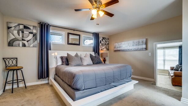 A bedroom with a bed, ceiling fan, artwork, and a chair. - Immaculate 2-bed in Dallas Close to Everything! (Dallas)