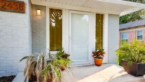 A house with a number '2438' on the wall, a front door, and potted plants on the porch. - Immaculate 2-bed in Dallas Close to Everything! (Dallas)