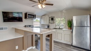 A modern kitchen with a central island, stainless steel appliances, and a ceiling fan. - Immaculate 2-bed in Dallas Close to Everything! (Dallas)