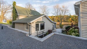 Une maison de plain-pied avec un toit en pente, un porche à l’avant et une petite terrasse.