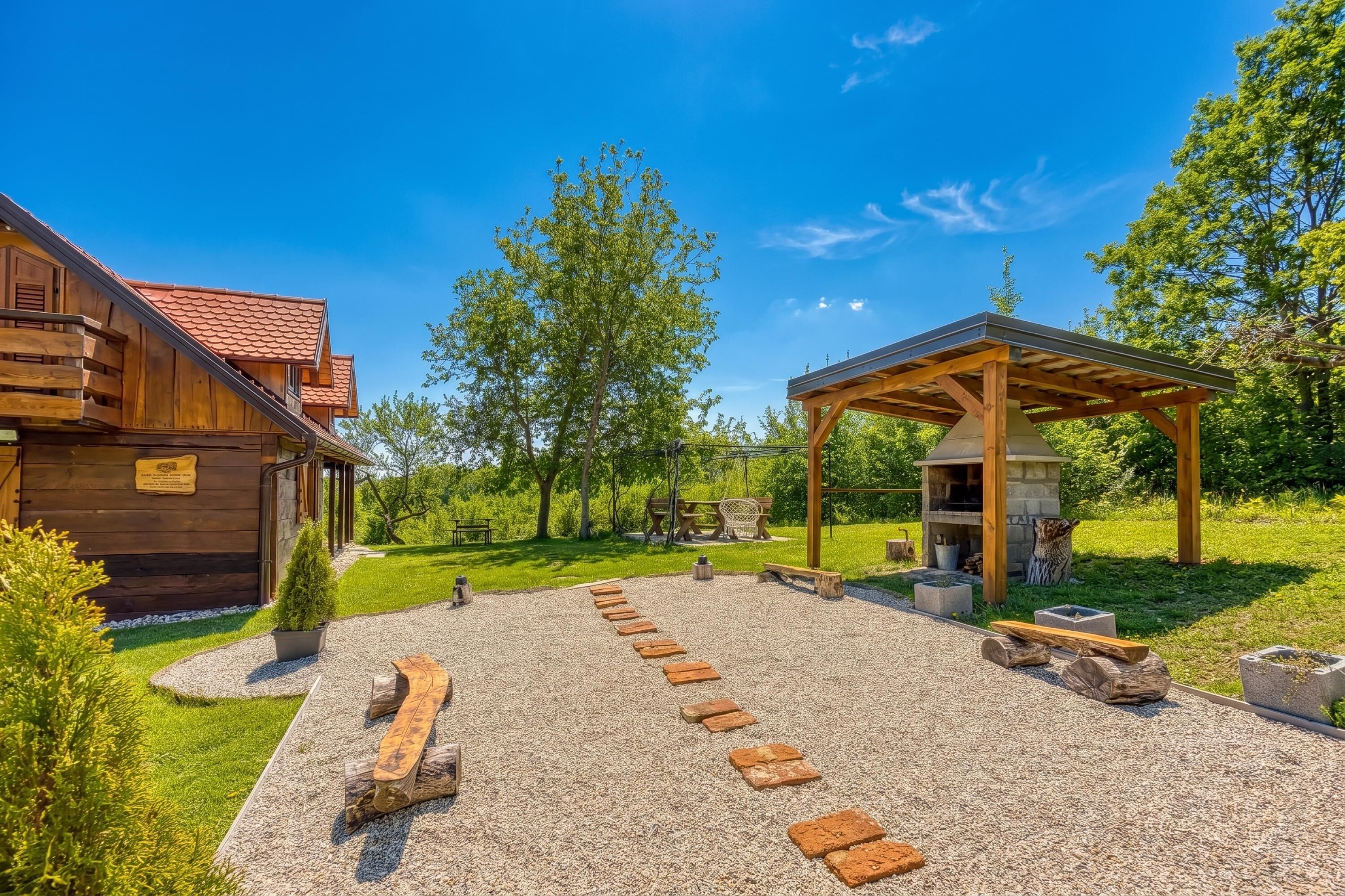 A wooden cabin with a patio, a barbecue area, and a stone pathway.